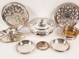 a lot of silver dishes on a white table