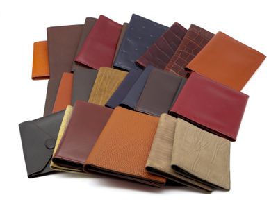 plusieurs portefeuilles en cuir de différentes couleurs empilés les uns sur les autres