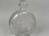 a clear glass bottle with a clear lid on a white surface
