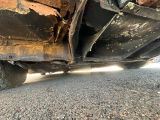 une voiture rouillée garée sur le bord de la route