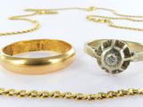 two rings and a gold chain on a white surface
