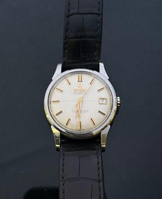a close up of a watch on a black surface with a black background