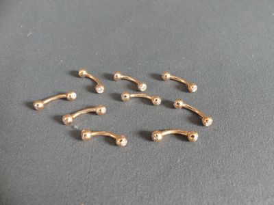 un ensemble de cinq piercings de nez dorés sur un fond gris