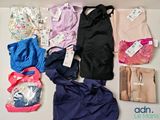 beaucoup de vêtements et de sacs posés sur la table