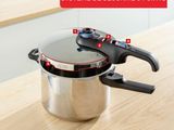 an image of a pressure cooker sitting on top of a wooden table