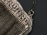 silver metal chainmail purse on black surface with chain