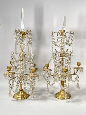 trois chandeliers en cristal sont posés sur une surface blanche