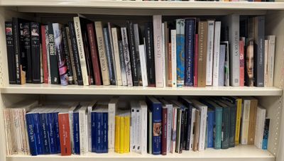 a book shelf with many books on it in a room