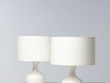 a pair of white table lamps on a white surface