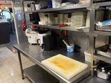 une grande cuisine avec de nombreux plans de travail en inox
