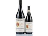 two bottles of wine sitting next to each other on a white surface