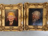 Deux tableaux représentant un homme et une femme sont exposés dans des cadres dorés.