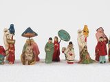 many figurines of people with umbrellas on a white surface