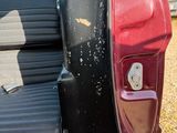 a red and black scooter sitting in the back of a car