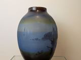 un vase bleu posé sur une table en verre