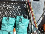 many bags of garbage sitting on the ground next to a building