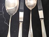 several spoons, forks, and knives are laid out on a black surface