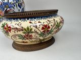 a vase with a lid sitting on a wooden stand