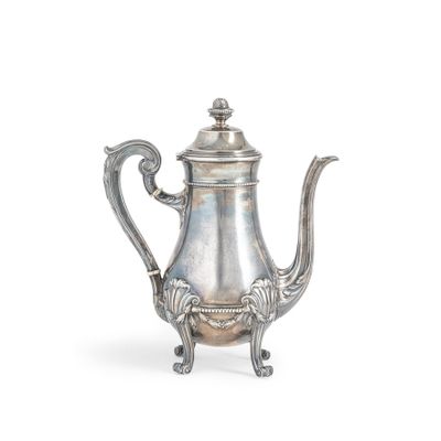 une théière ancienne en argent, munie d'une anse et posée sur un socle