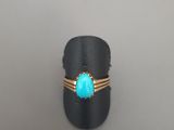 un gros plan d'une bague sertie d'une pierre turquoise