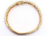 a close up of a gold bracelet on a white surface