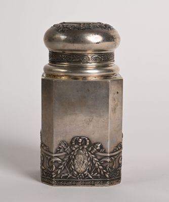 une salière ancienne en argent posée sur une surface blanche