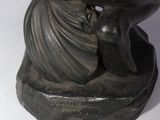 a statue of a woman holding a large black object