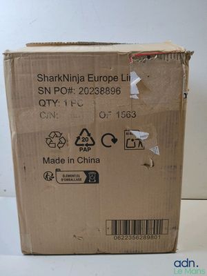 une boîte en carton sur laquelle est collé un autocollant, posée sur une table