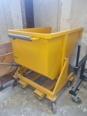 un conteneur jaune posé sur un chariot dans un garage