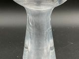 a clear glass vase sitting on a black surface