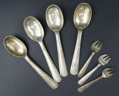 six silver spoons and forks arranged in a circle on a black surface