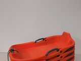 three orange plastic baskets with handles on a white surface