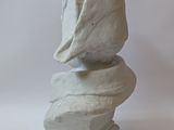 a white sculpture of a shell on top of a rock