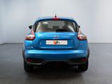 the rear end of a blue car in a white room