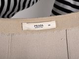 a close up of a woman holding a prada bag in her hand