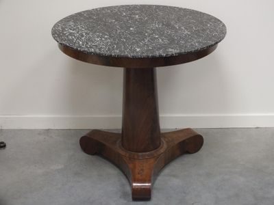 une petite table avec un plateau en marbre dans une pièce