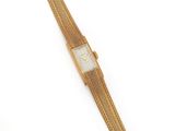 une image représentant une montre en or avec un cadran blanc et un bracelet en or