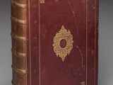 un vieux livre rouge orné d'un médaillon doré sur la couverture