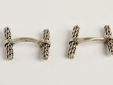 une paire de boutons de manchette en argent sur fond blanc