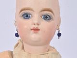 a close up of a doll with blue eyes on a white background
