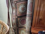 a wicker chair next to a wicker chair with a rug on it