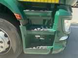 a green semi truck parked on the side of the road