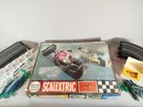 une boîte de Scalextric posée sur une table à côté d'un circuit de train
