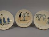three porcelain plates with pictures of people on them sitting on a table