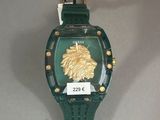 a green watch with a gold lion on the face