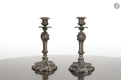 une paire de bougeoirs anciens en argent posés sur une table à miroir