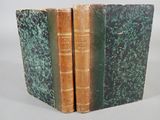 trois livres sont empilés sur une surface blanche