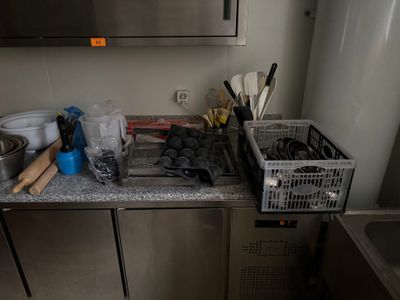 une photo d'une cuisine avec de nombreux ustensiles posés sur le plan de travail