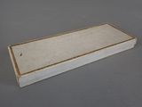 an image of a white box with gold trim on a gray surface