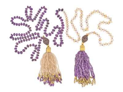 deux colliers en perles violettes et dorées ornés de pompons, sur fond blanc